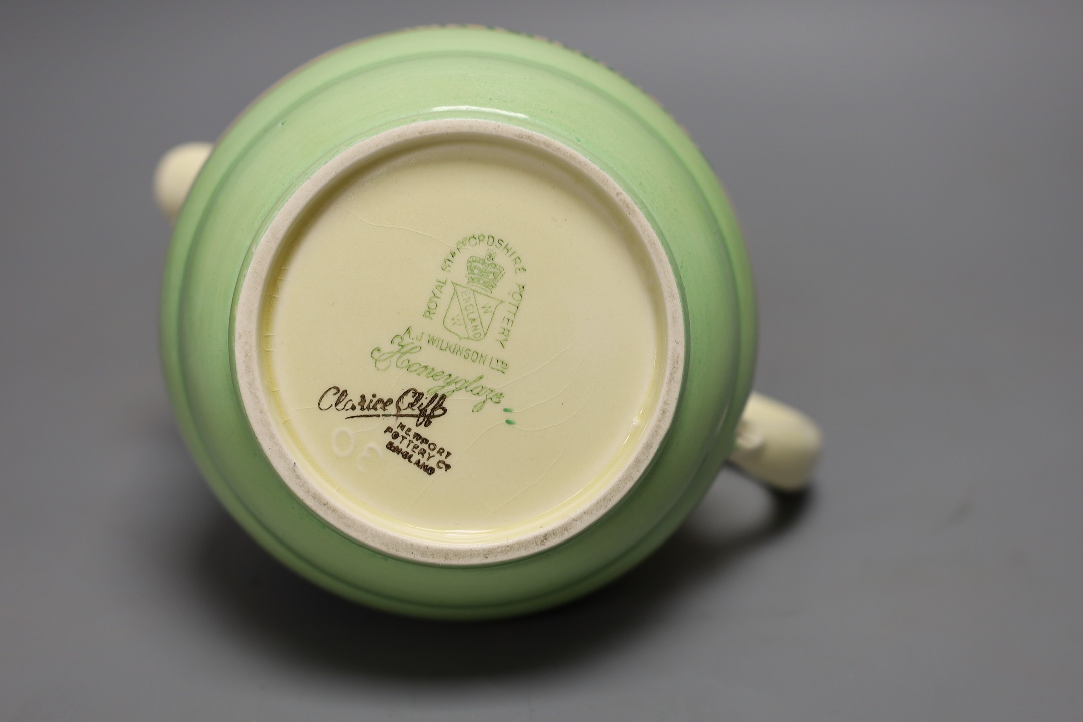 A Clarice Cliff crocus design milk jug and a Bizarre patterned side plate, jug 11.5 cms high